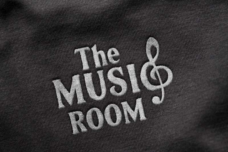 The Music Room logo embossed on dark fabric